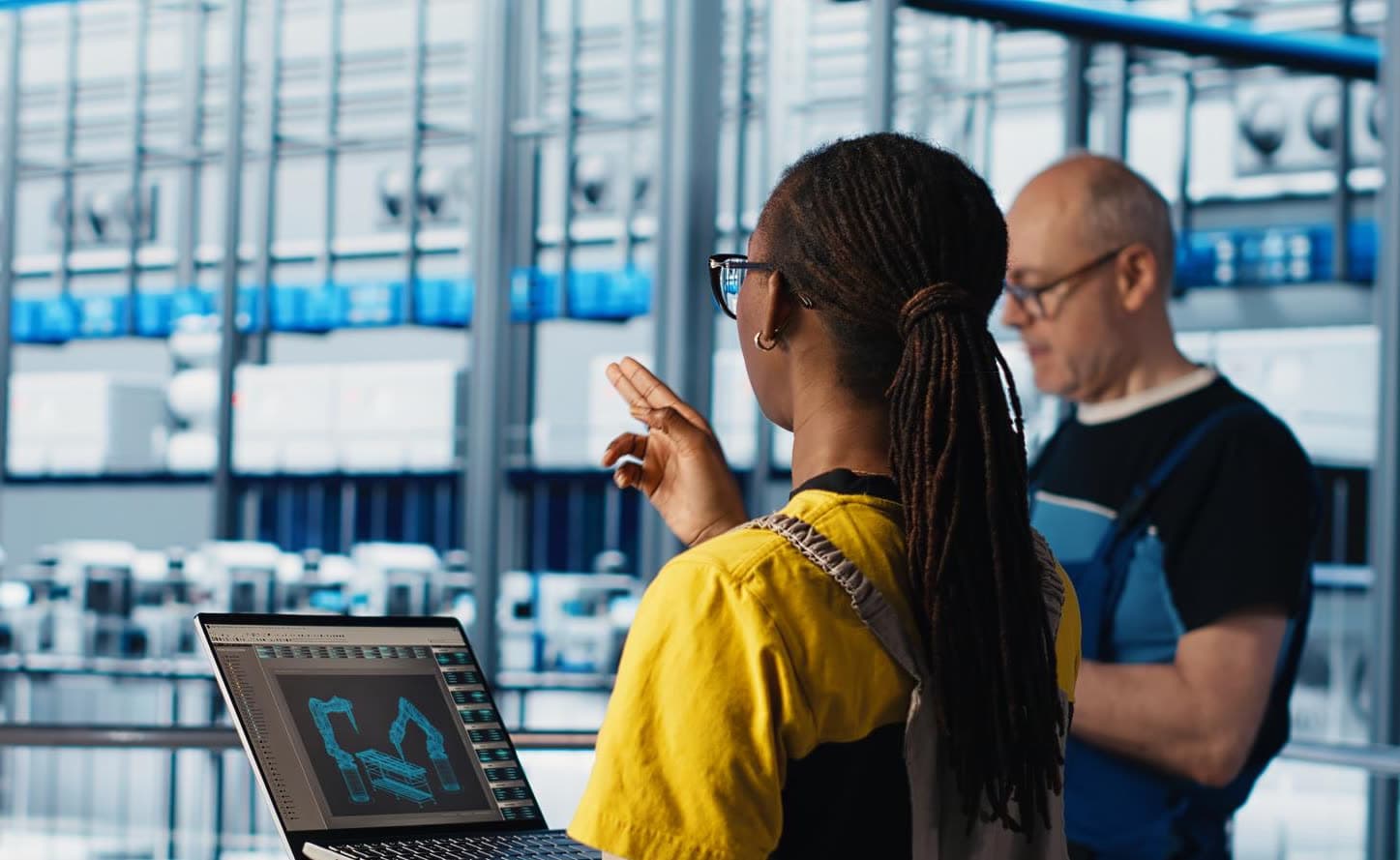 Two plant engineers reviewing a machine readout on the floor.